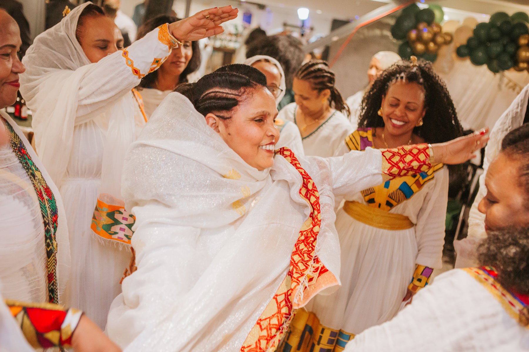 Guests of the Christening dancing and dressed in traditional Eritrean dress.