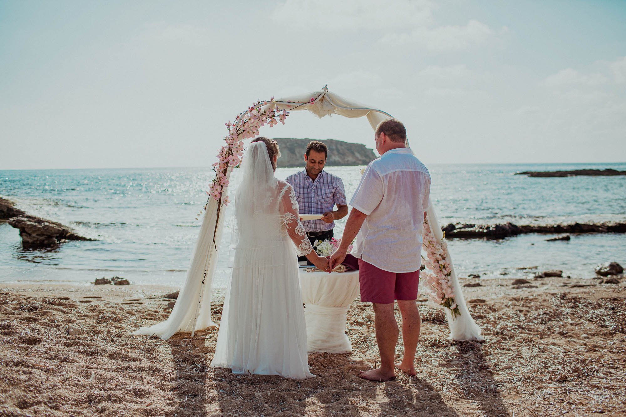 Groom marrying bride on St Georges beach peyia paphos