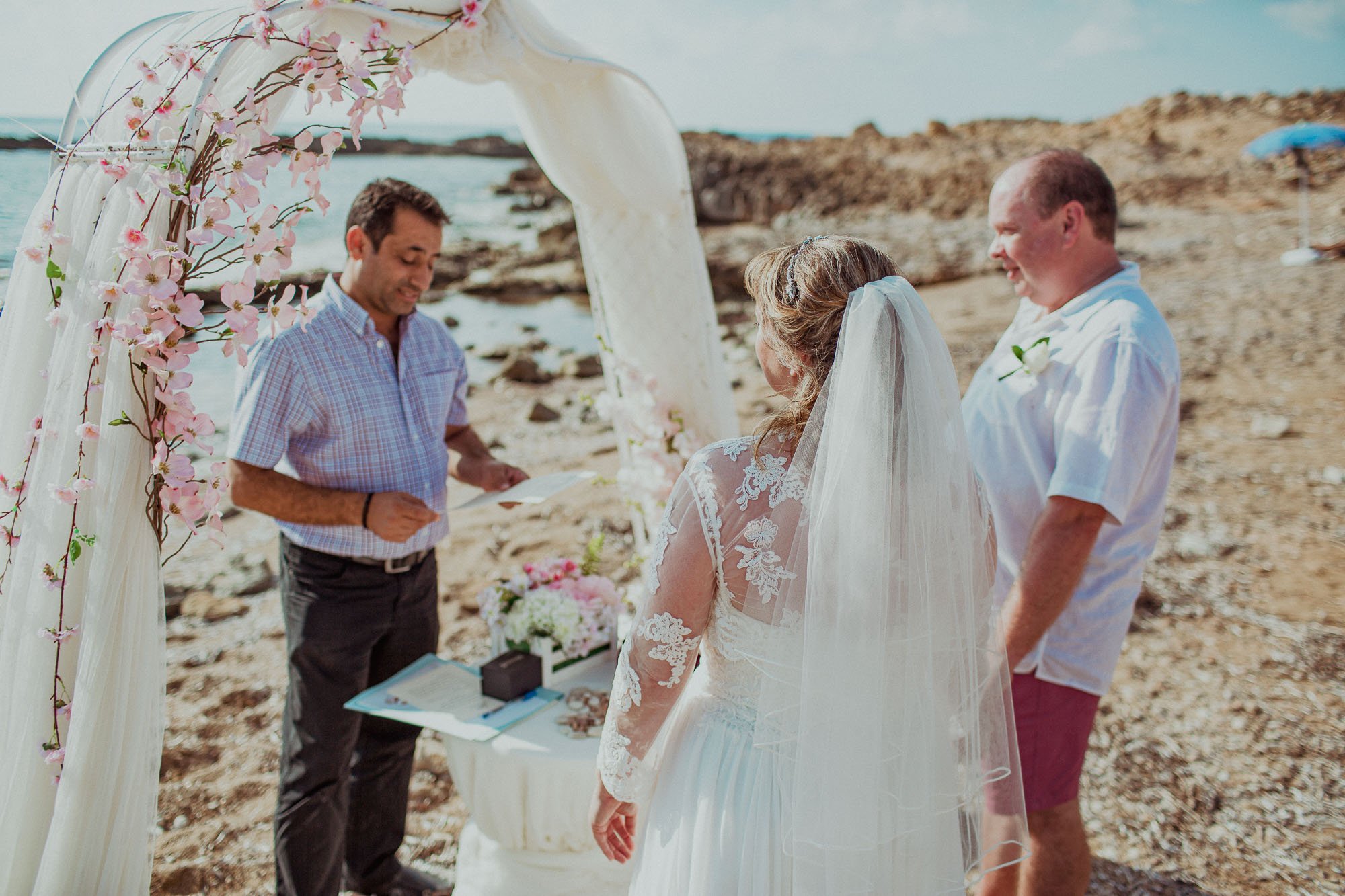 Groom marrying bride on St Georges beach peyia paphos