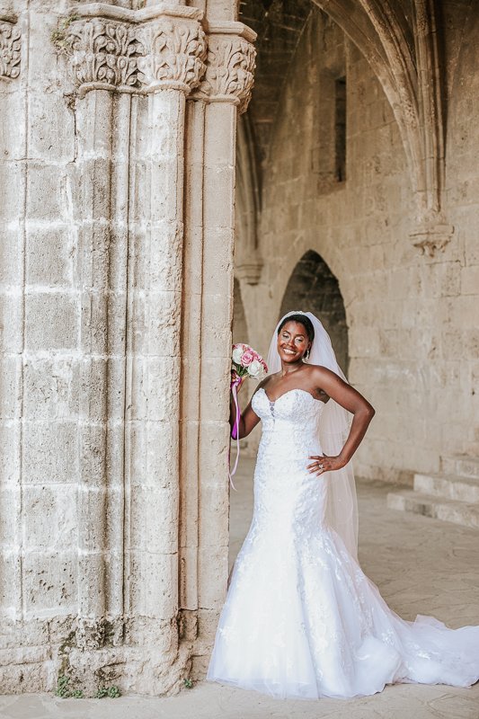 Bride posing after her wedding at Bellapais Abbey.