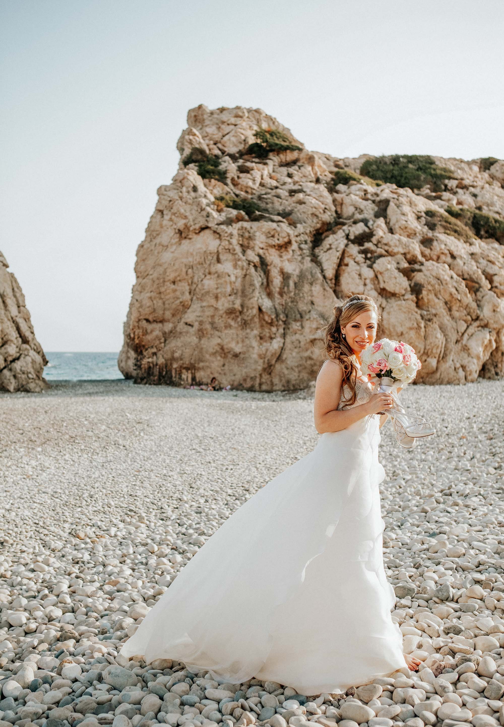 Bride standing by Aphrodites Rock (Petra tou Romiou) Cyprus.