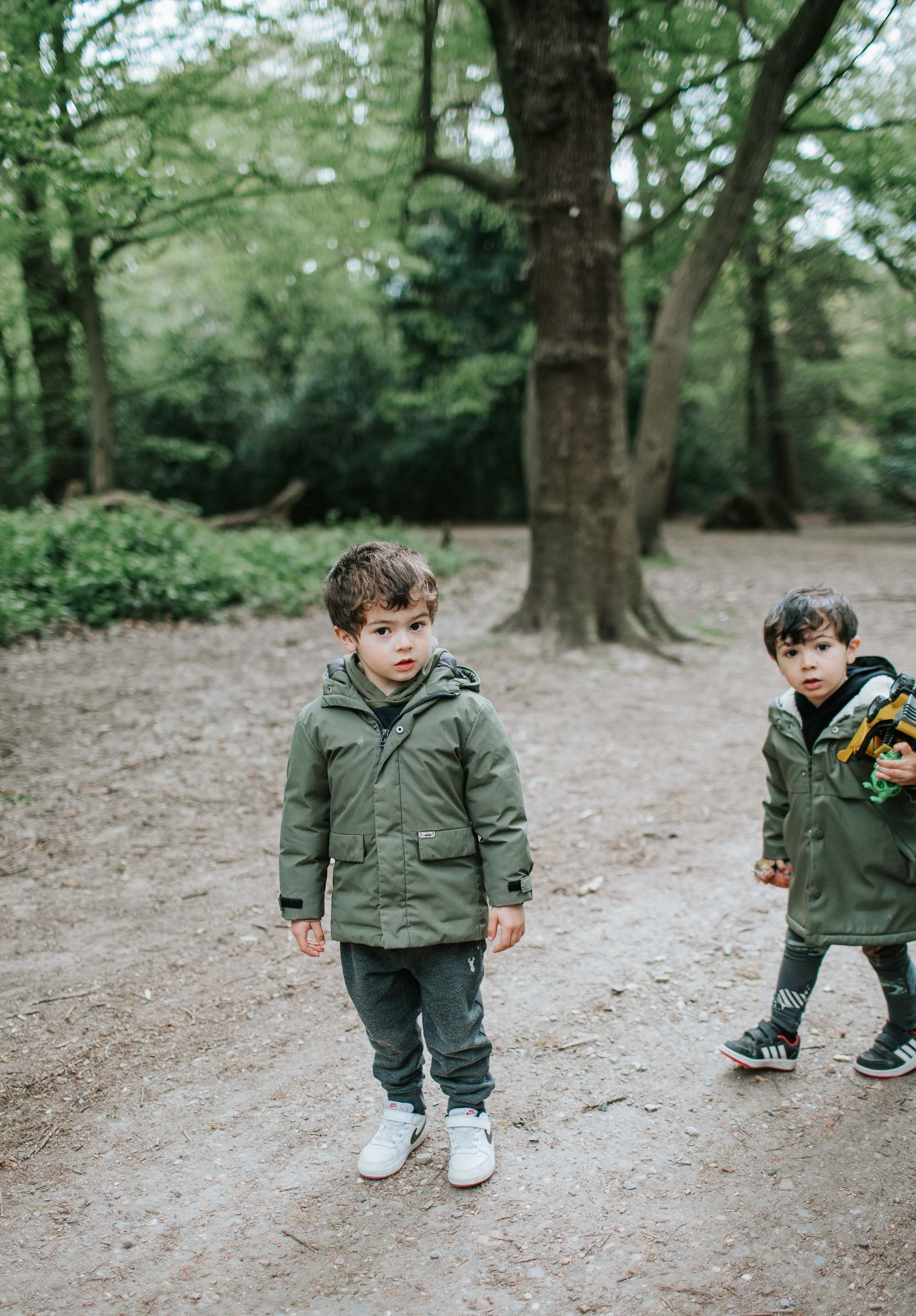 Two brothers walking along in Highgate Woods.