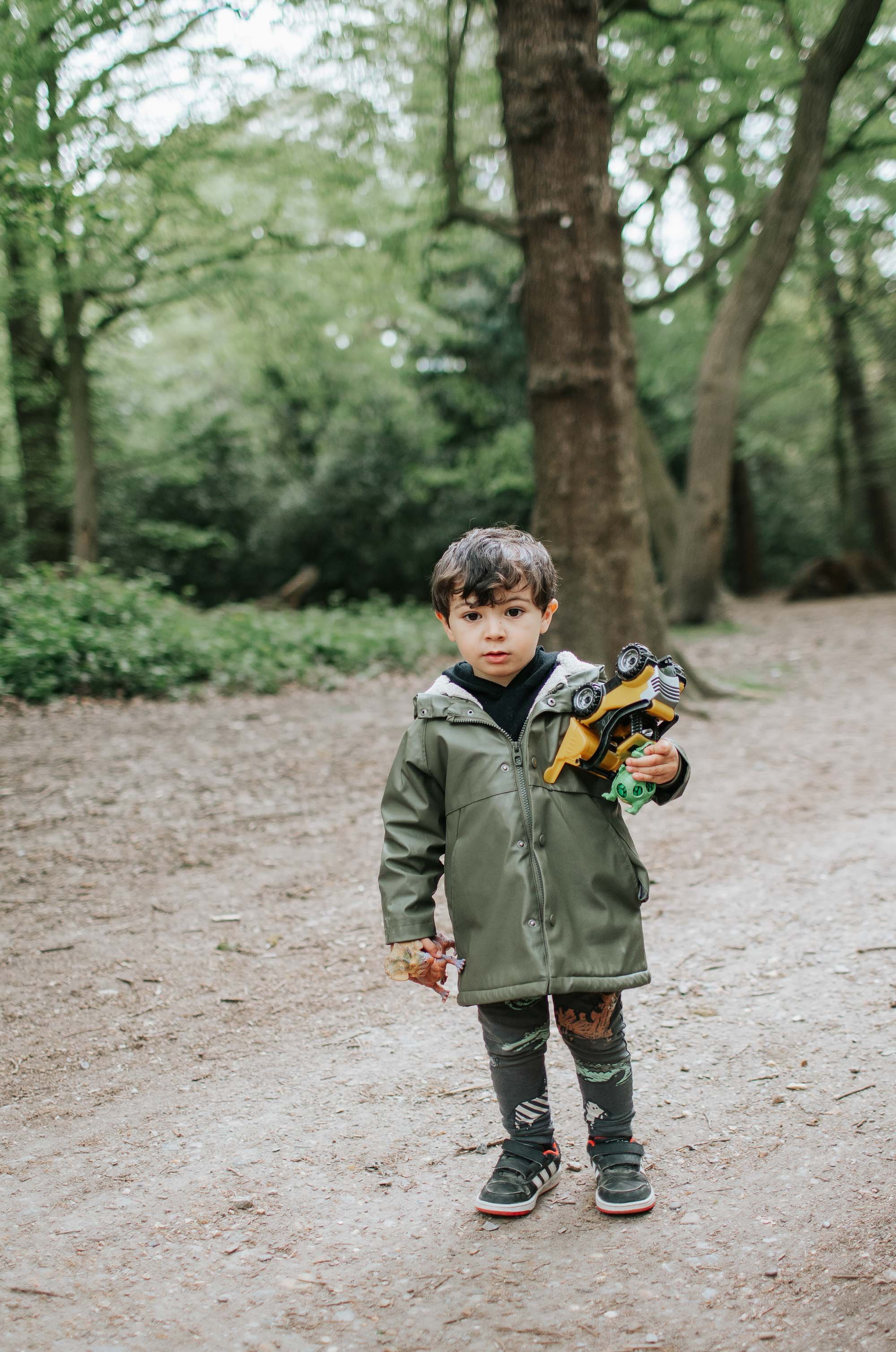 Young boy holding toy truck in Highgate Woods.