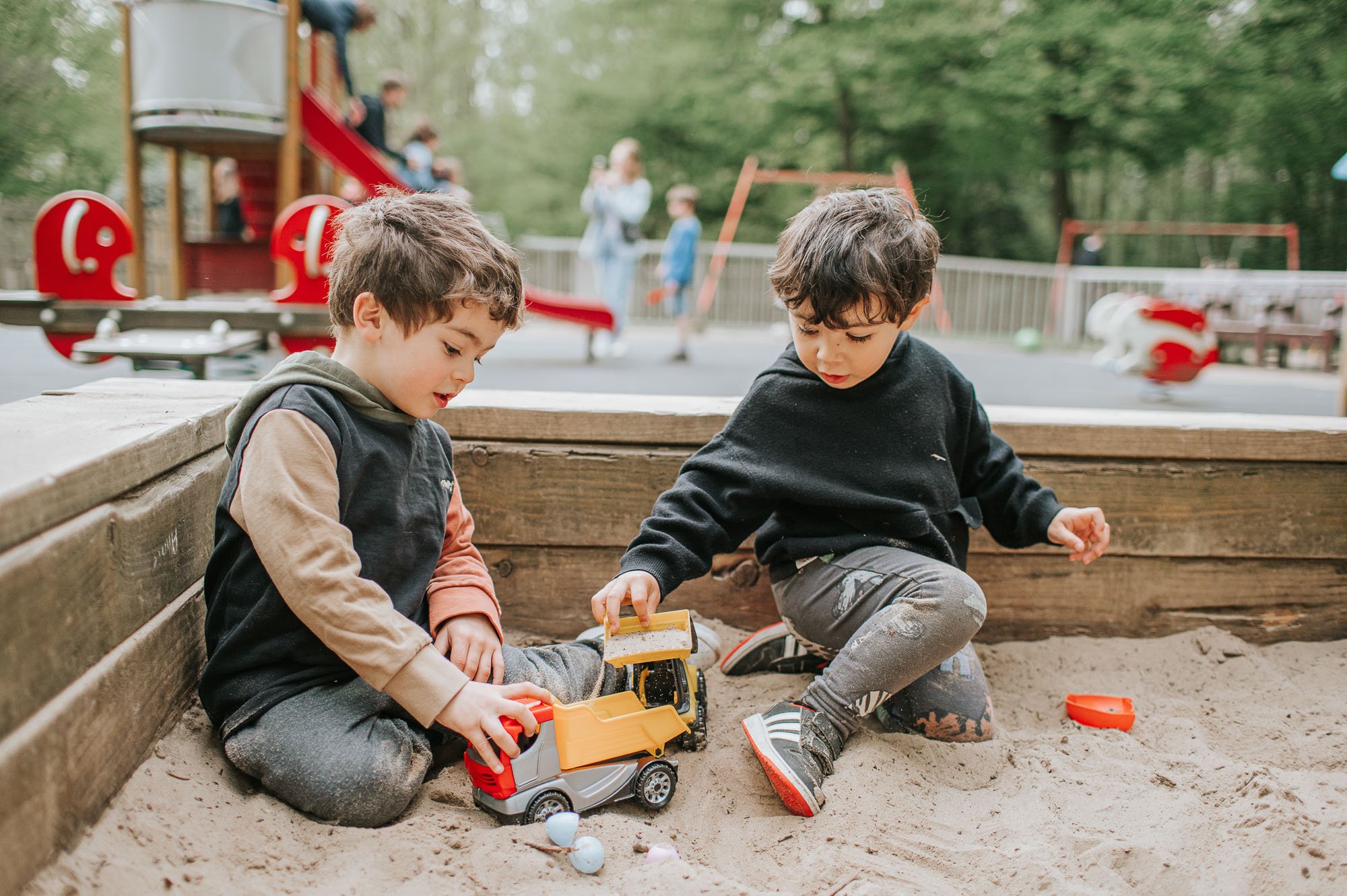 Two young boys playing in the sandpit in Highgate Woods.