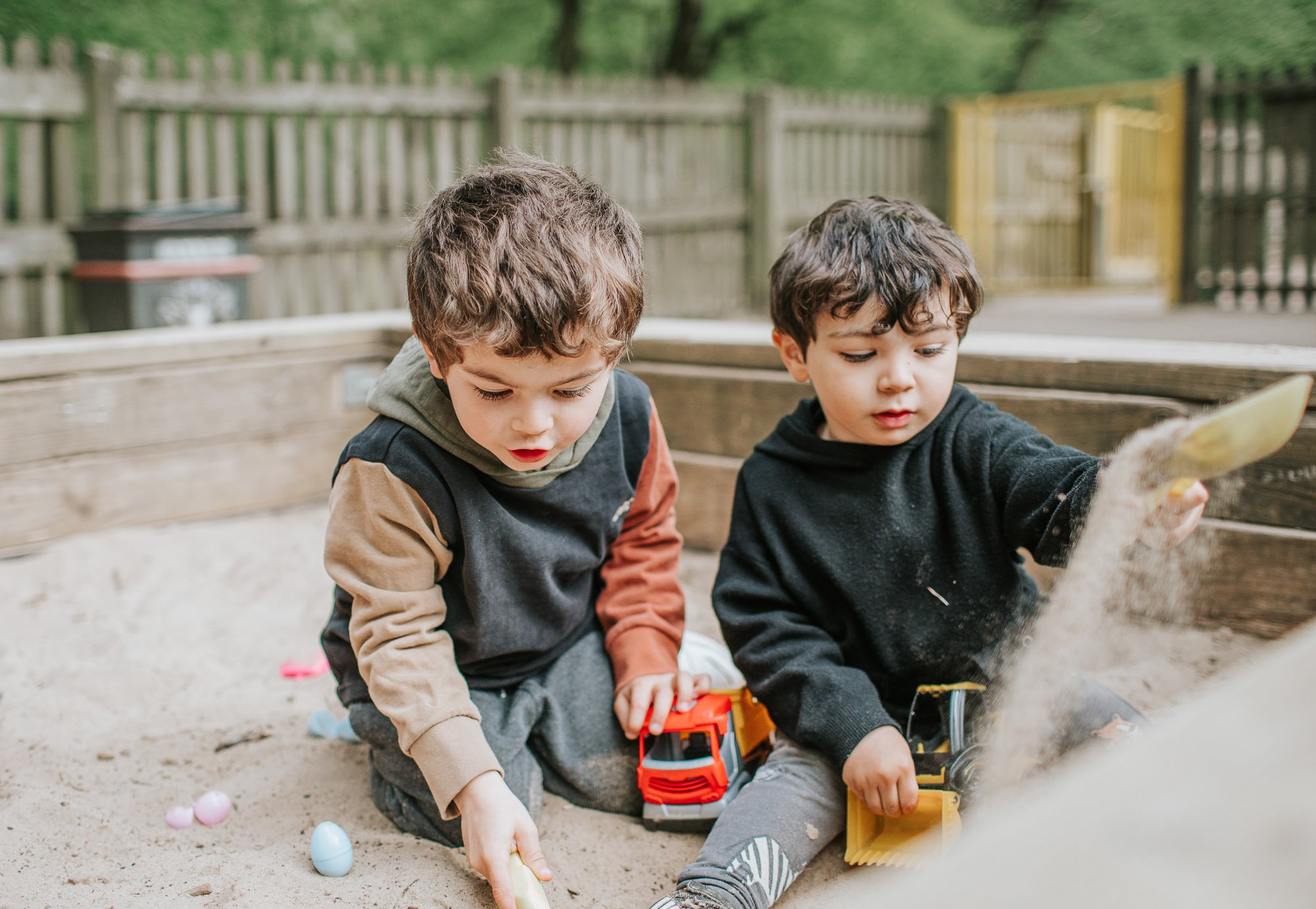 Two young boys playing in the sandpit in Highgate Woods.