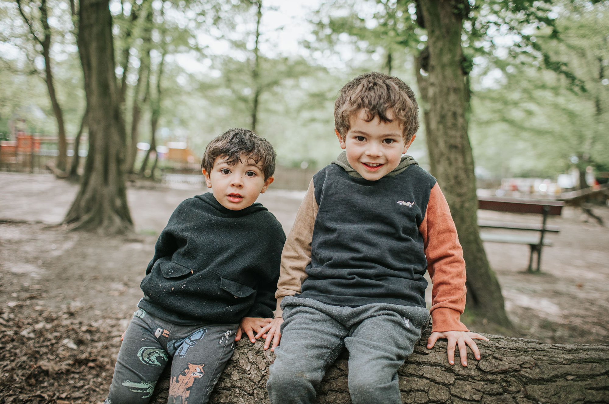 Young children sitting on log in Highgate Woods.