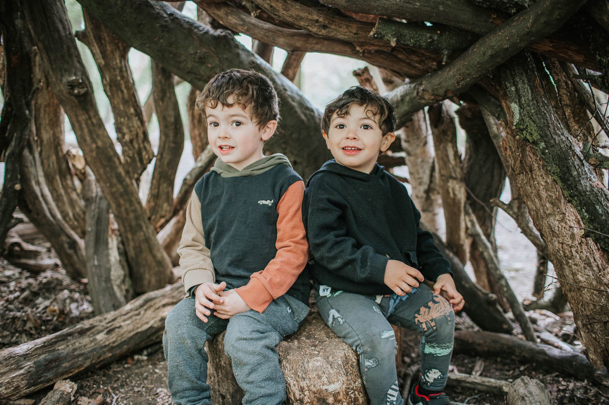 Young children sitting on log in Highgate Woods.