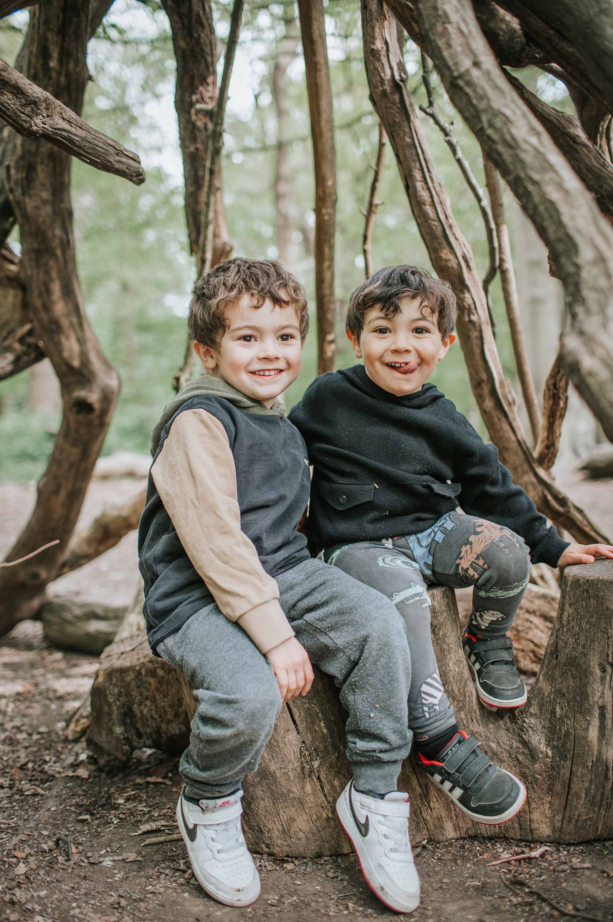Young children sitting on log in Highgate Woods.