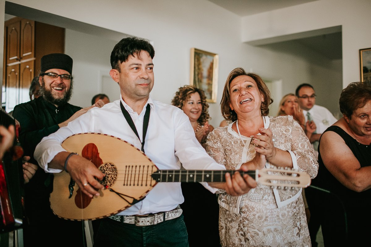 Greek Cypriot wedding musician playing at wedding stolisma with mother of groom clapping.