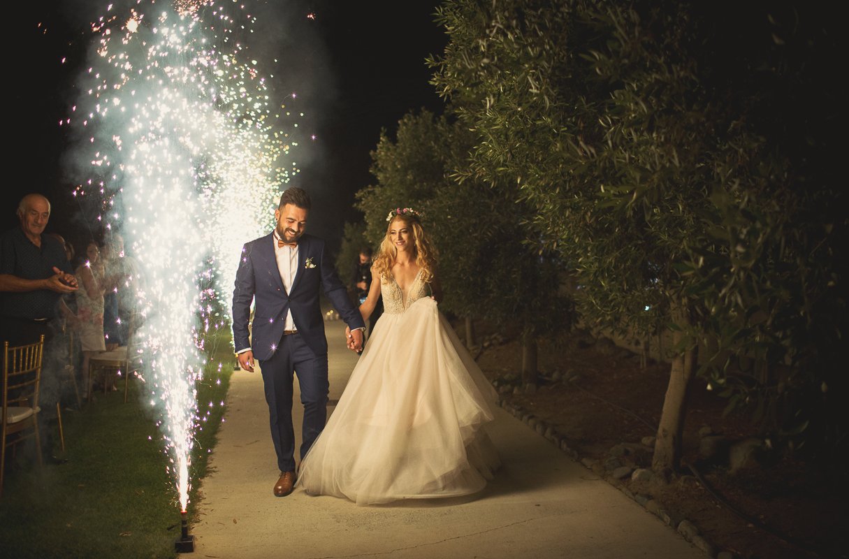 Couple make entrance with fireworks at aes ambelis winery.
