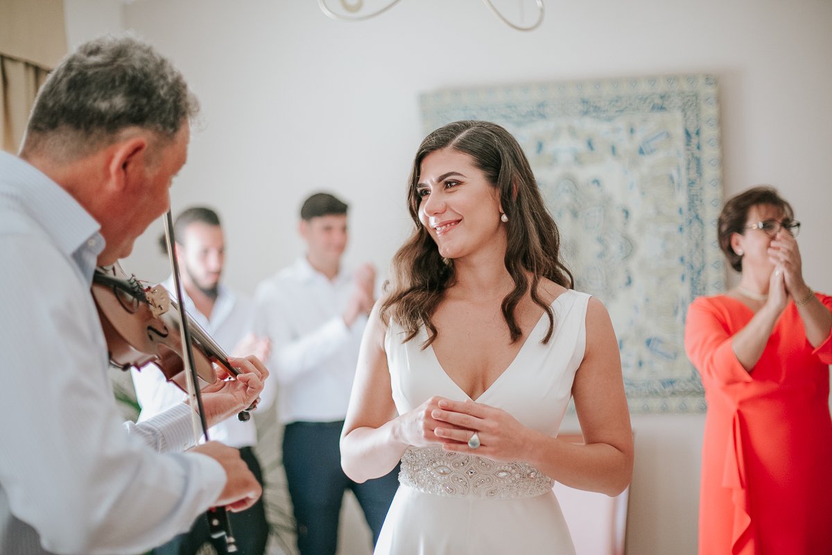 Bride and violin player at greek orthodox wedding preparations (stolisma).