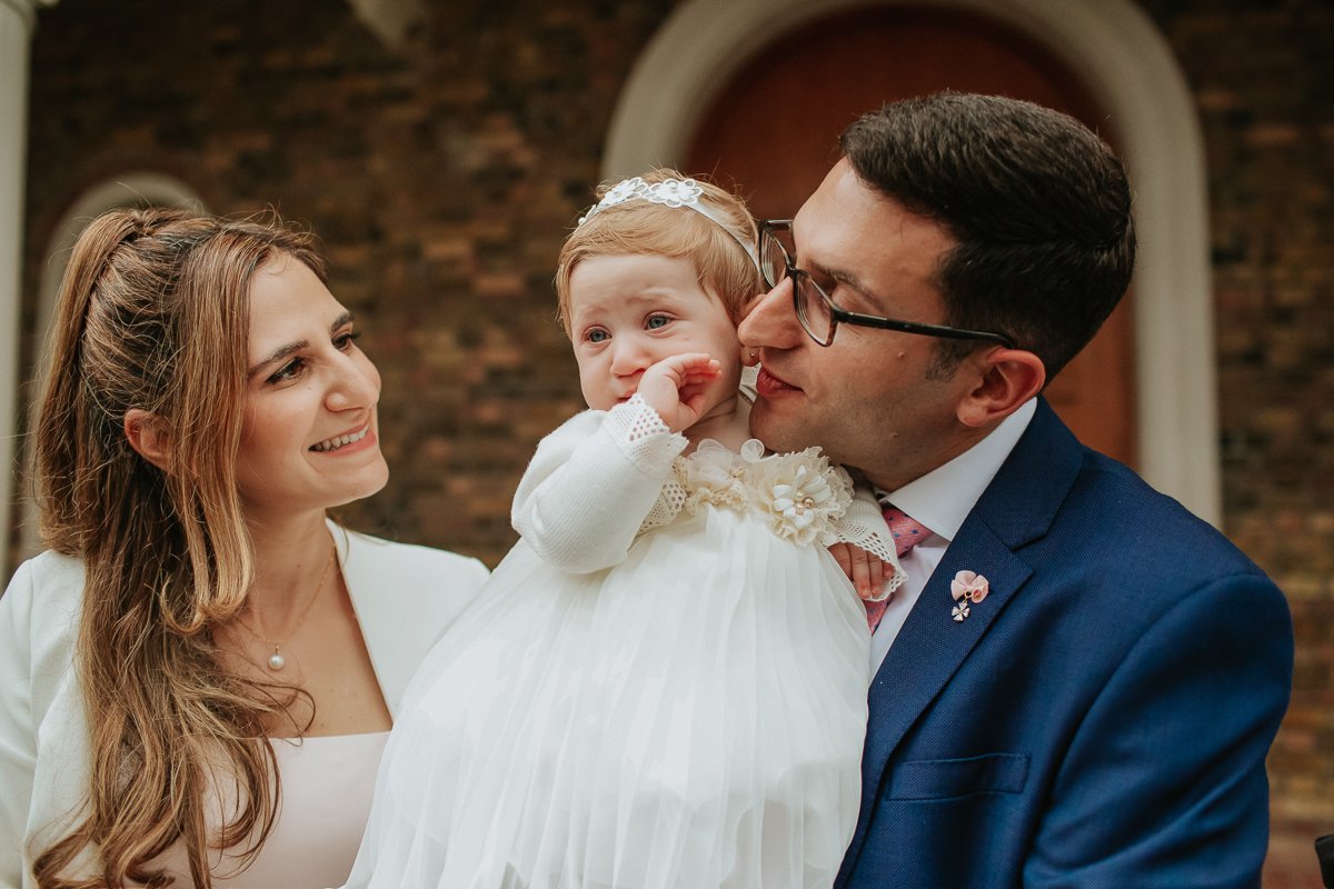 Baby Amalia and her mum and dad at her Christening in a greek church.