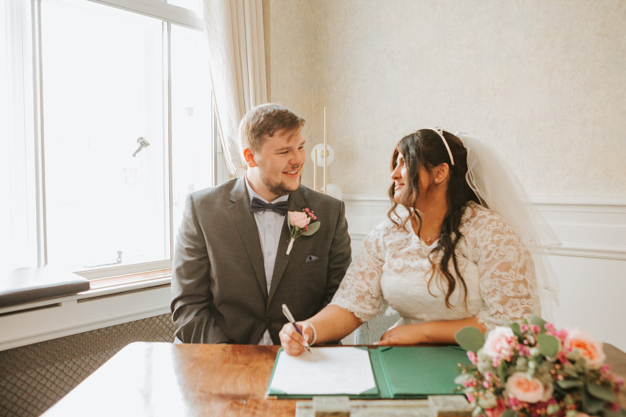  Newly married bride and groom signing the register at Wandsworth Town Hall. 