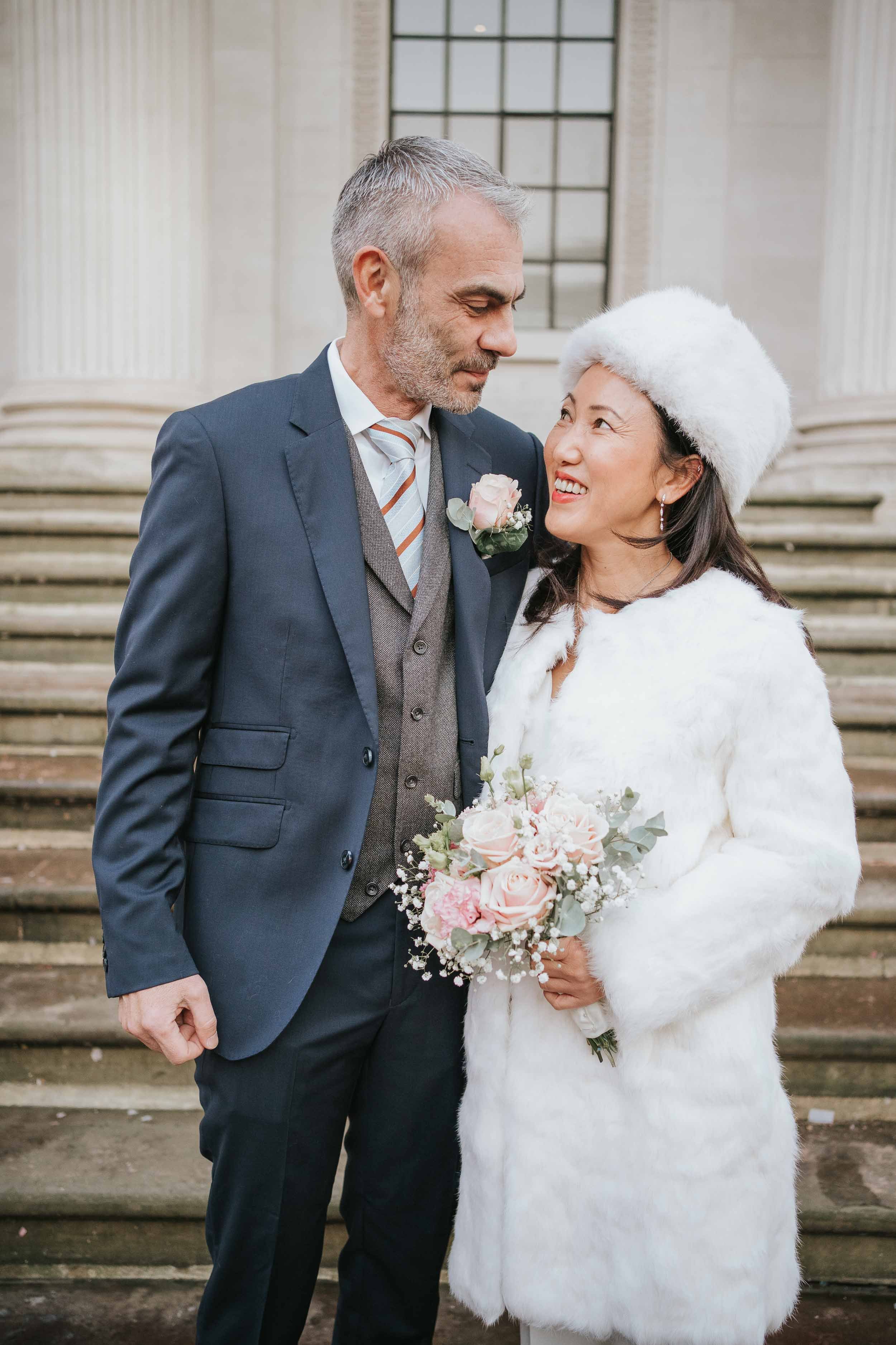  Bride and groom standing outside Marylebone Old Town Hall. 