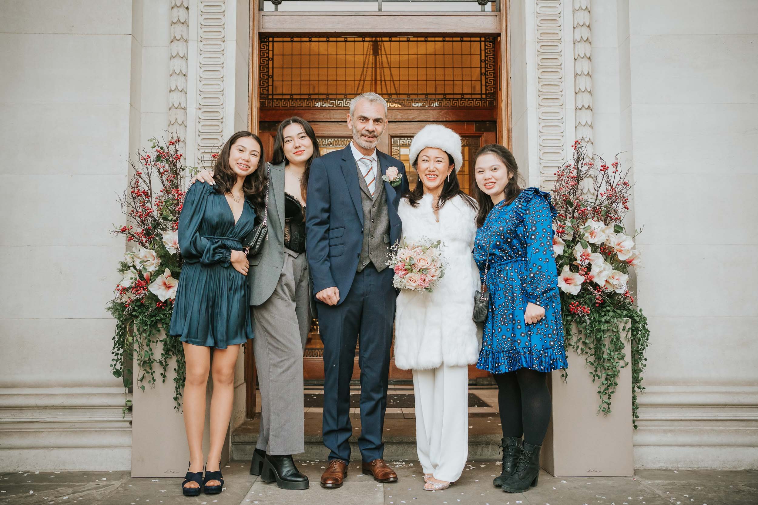  Bride, Groom and their three daughters pose outside Marylebone Old Town Hall. 