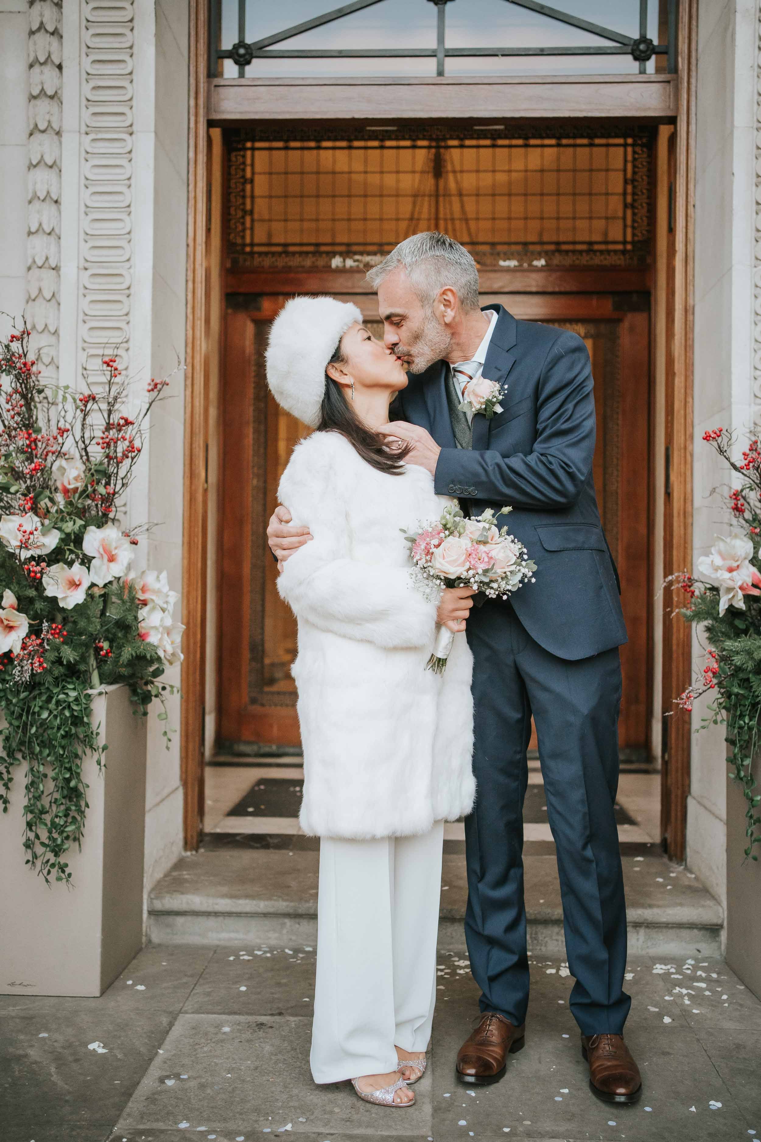  Bride and Groom kissing while having their wedding photography outside Marylebone Old Town Hall. 