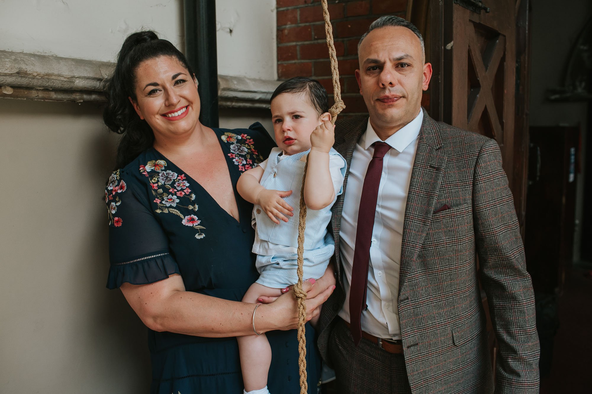  Newly christened baby Tommy and his parents standing outside St Mary’s Greek Orthodox Church in Camberwell, London. 