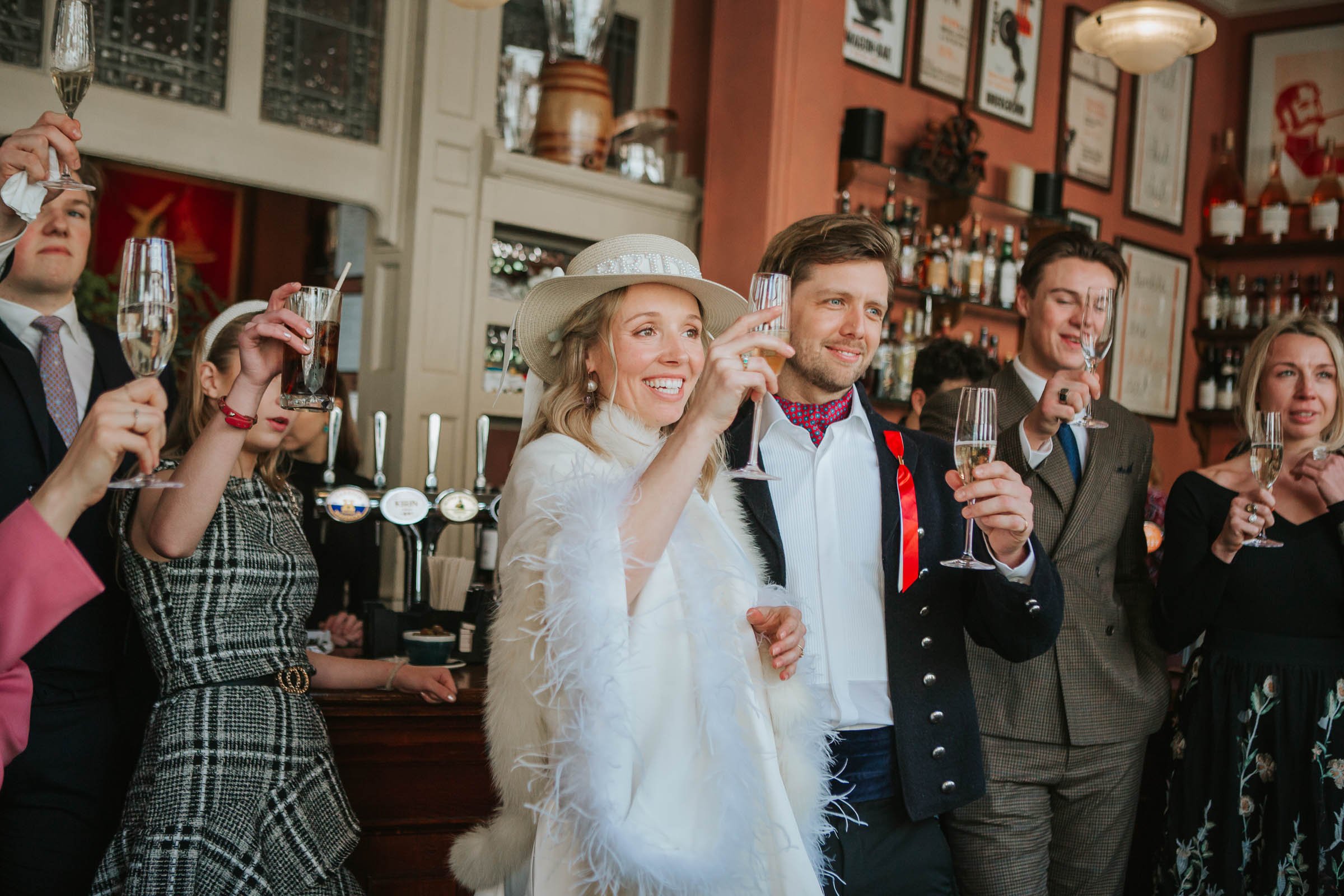  Guests and the bride and groom raise their glasses to a toast after the wedding speeches inside The Surprise Pub in Chelsea. 