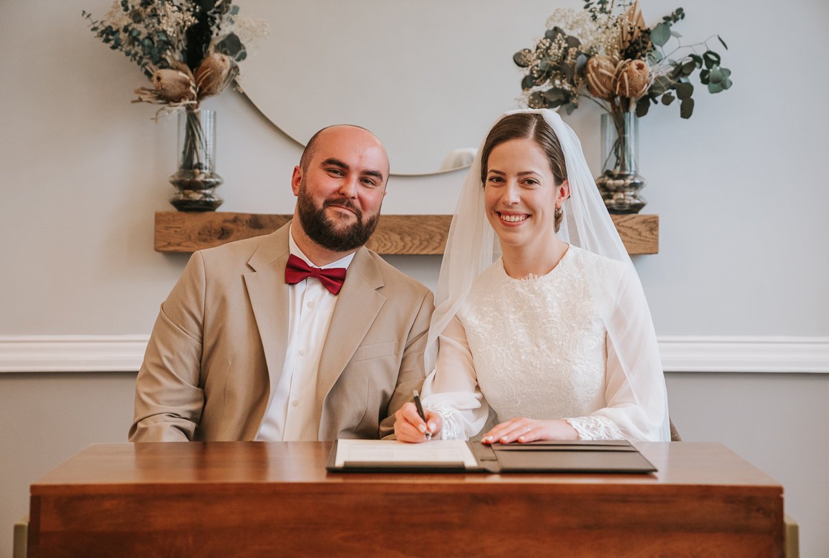  Edina and Zsolt, the bride and groom, sign the  registry after they got married in the wedding ceremony room at Islington Town Hall. 