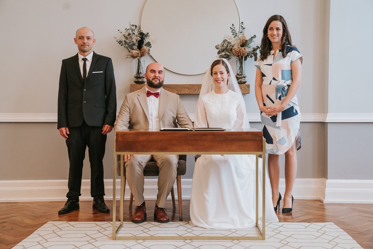  Edina and Zsolt, the bride and groom, sign the  registry and pose with the witnesses after they got married in the wedding ceremony room at Islington Town Hall. 