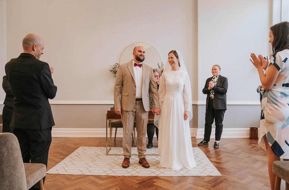  Edina and Zsolt, the bride and groom, getting a round of applause after the got married in the wedding ceremony room at Islington Town Hall. 