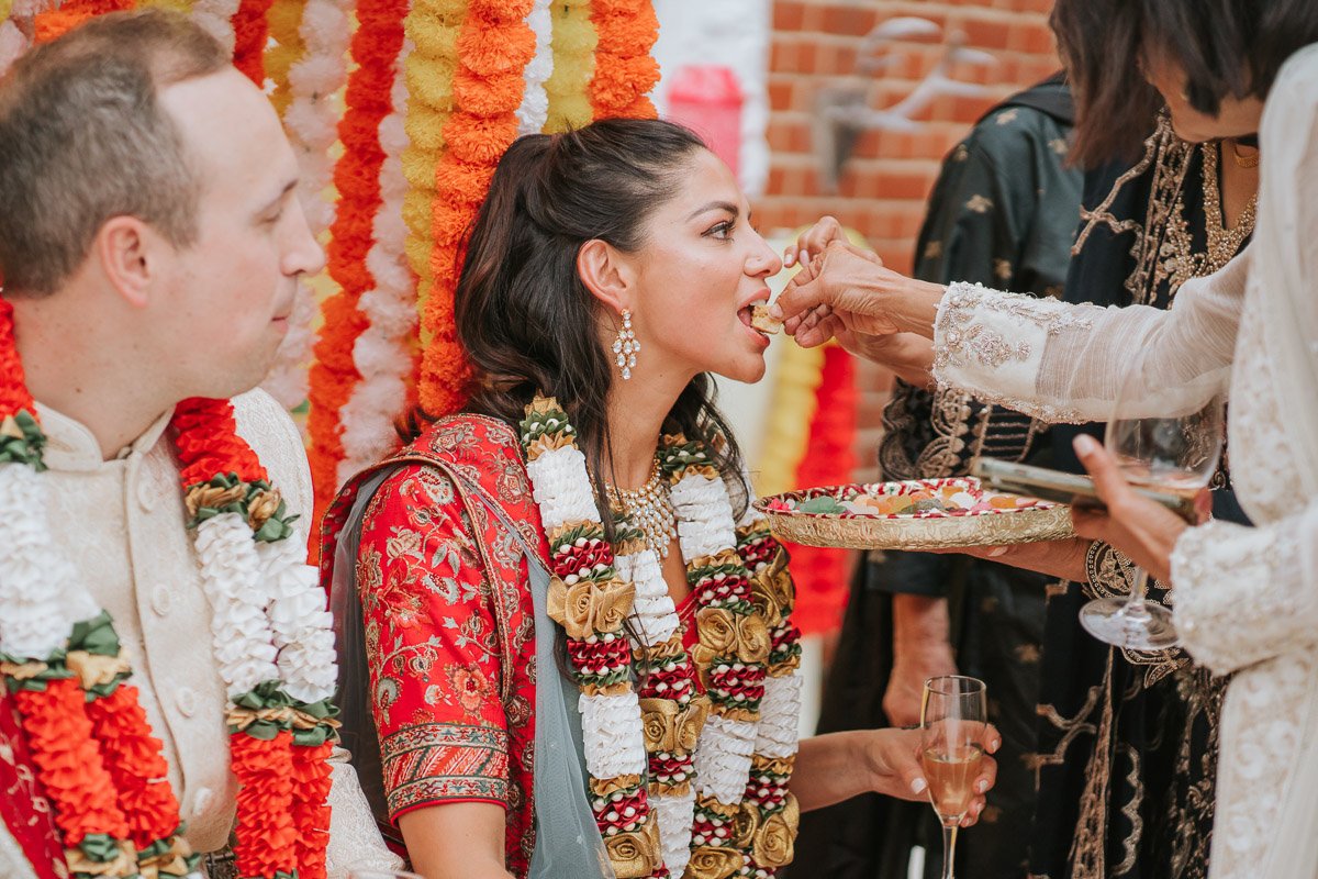  Bride and Groom eat sweet treats at their Mehndi Party. 