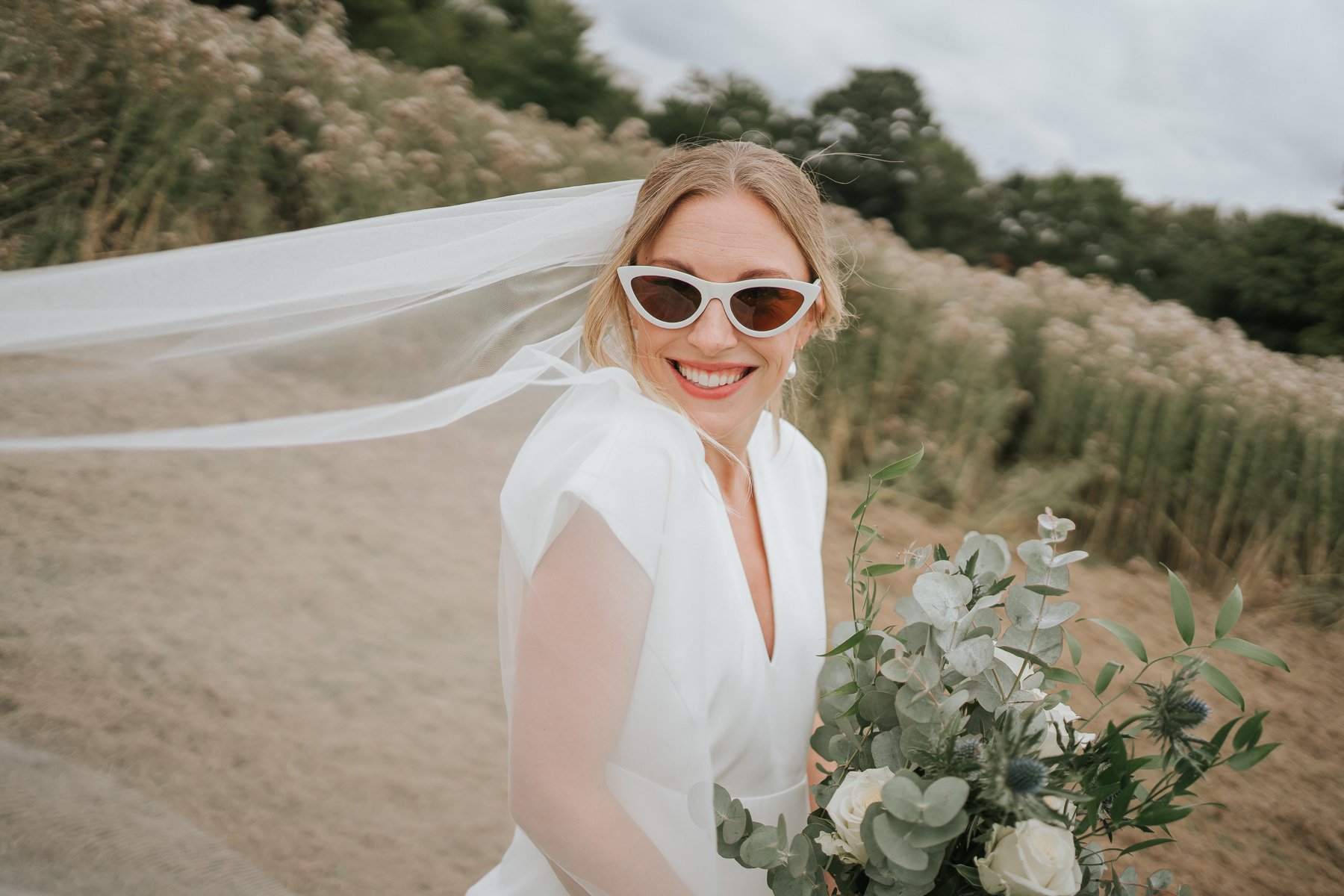  The lovely and happy Felicity on her wedding day poses for the camera wearing her matching retro sunglasses 