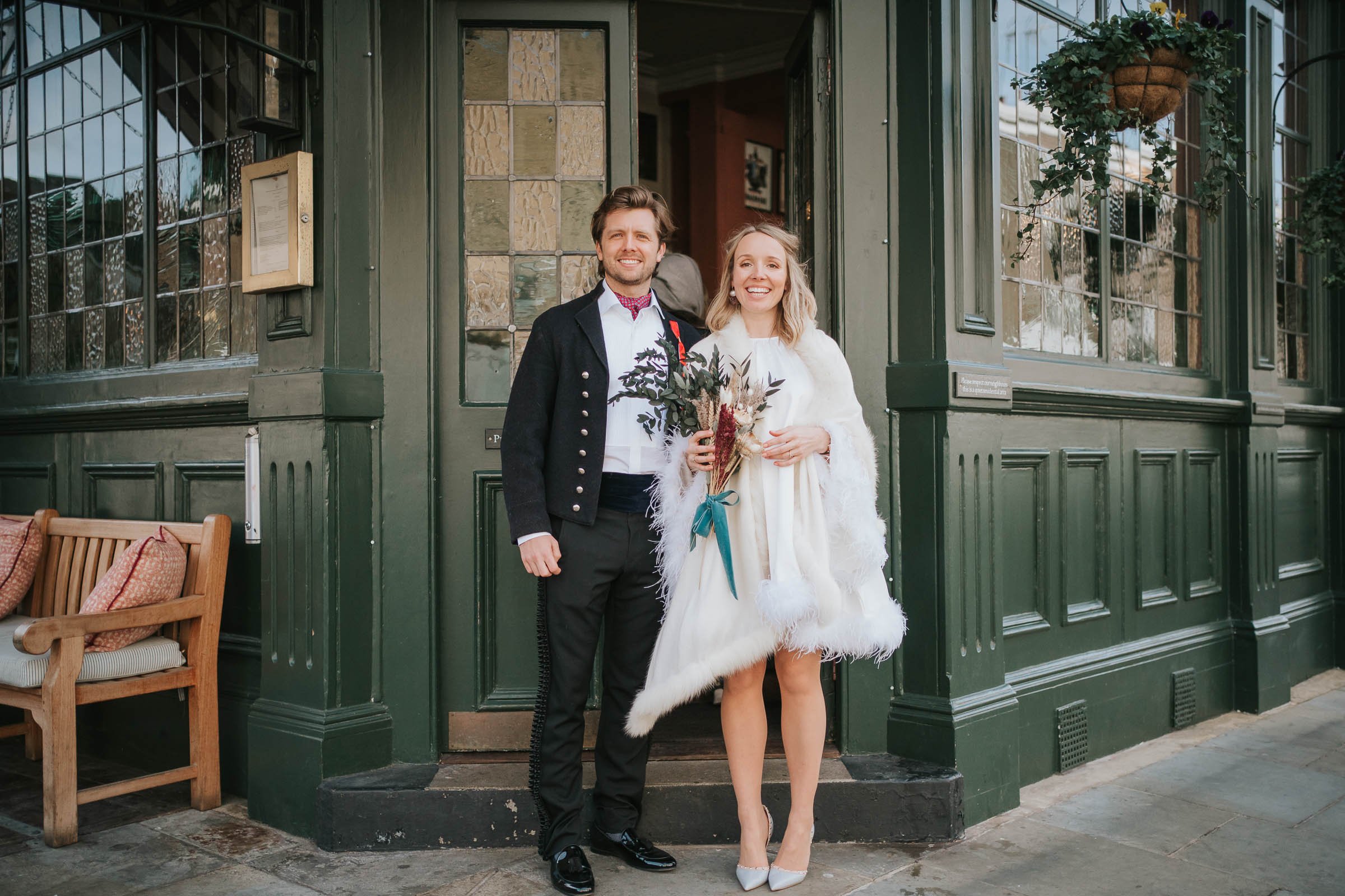  A newly married bride and groom pose outside the front door of the Surprise Pub in Chelsea. 