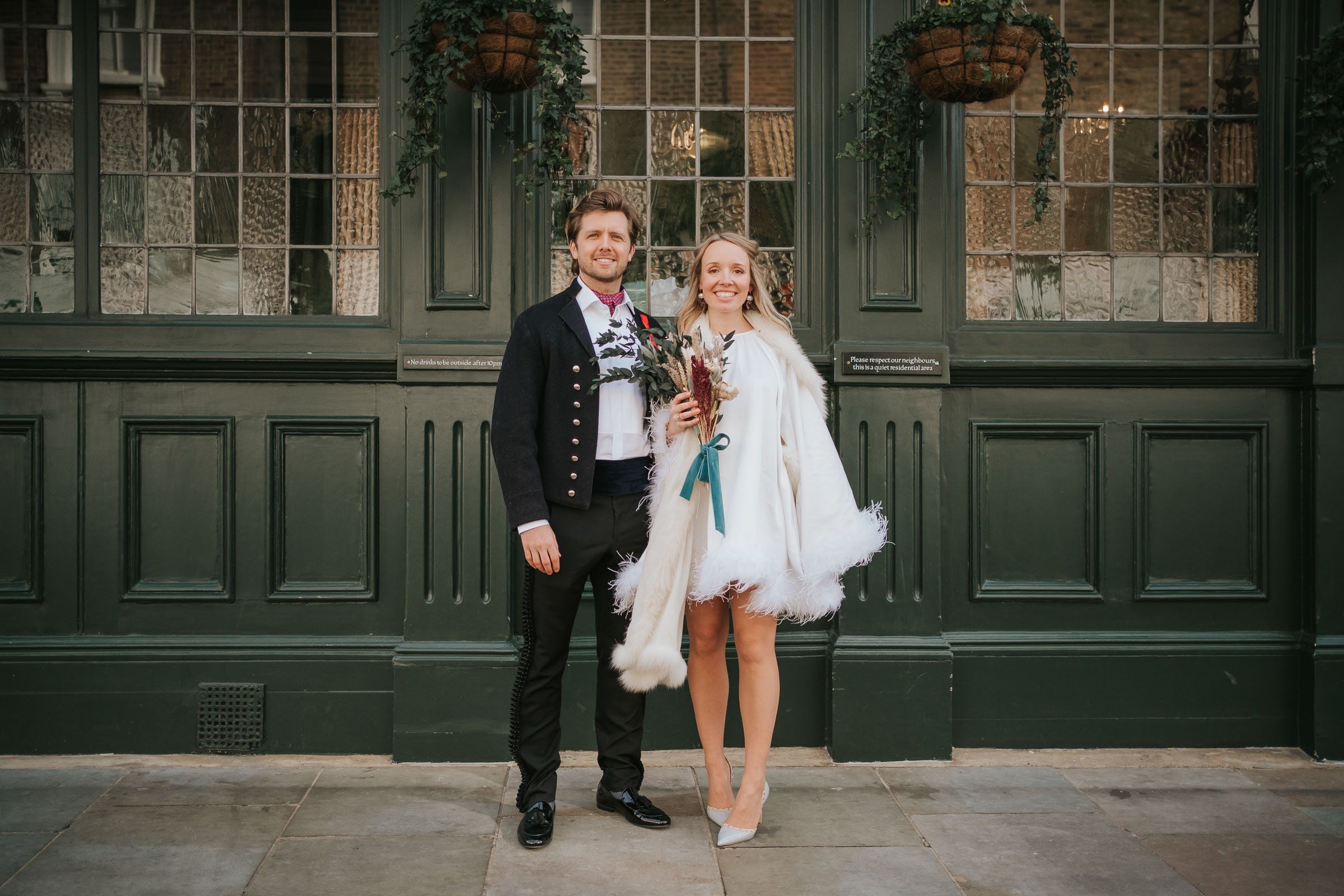  A newly married bride and groom pose outside the Surprise Pub in Chelsea. 