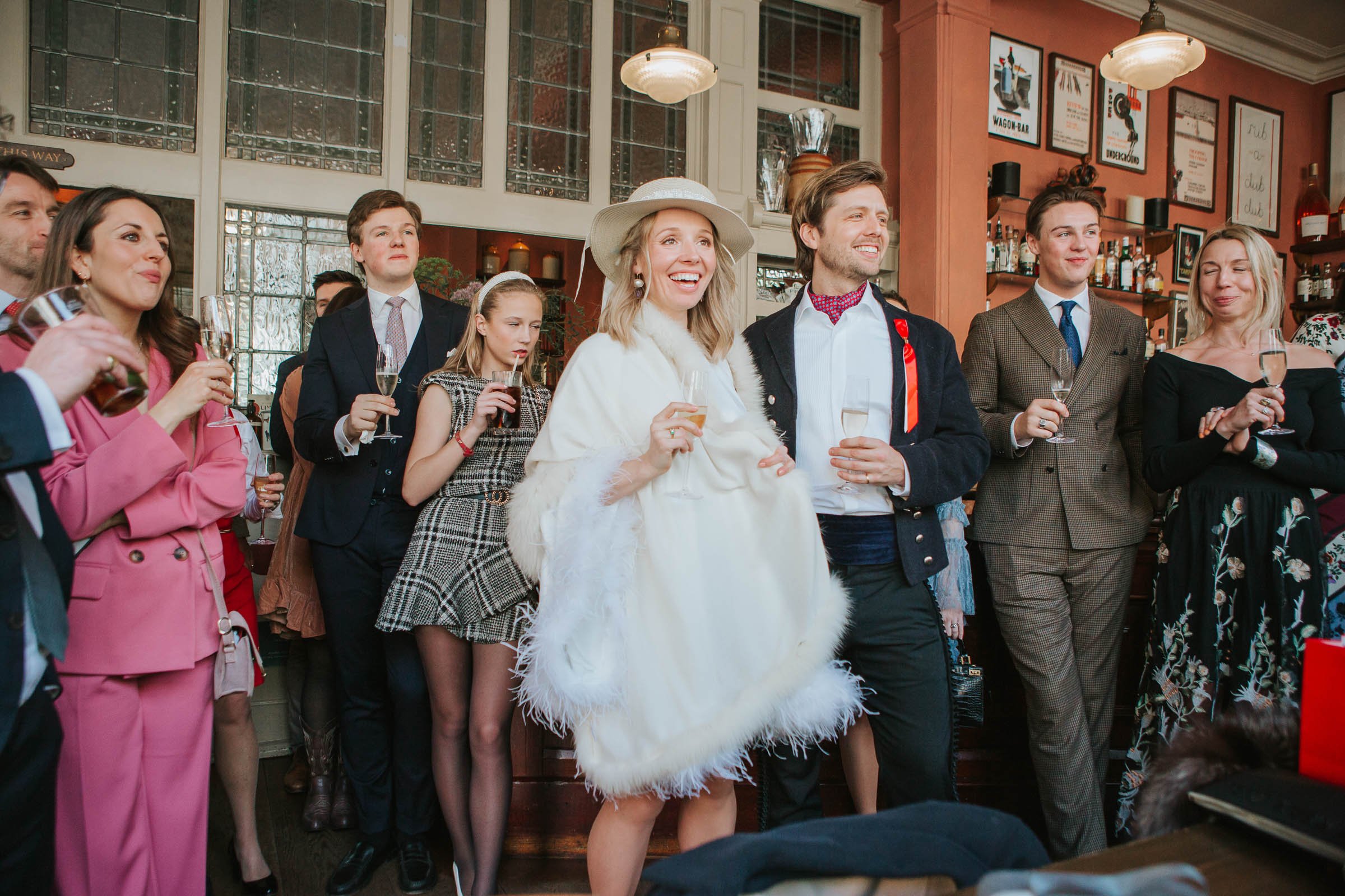  Bride and groom and guests laugh at wedding speeches at the Surprise Pub in Chelsea. 