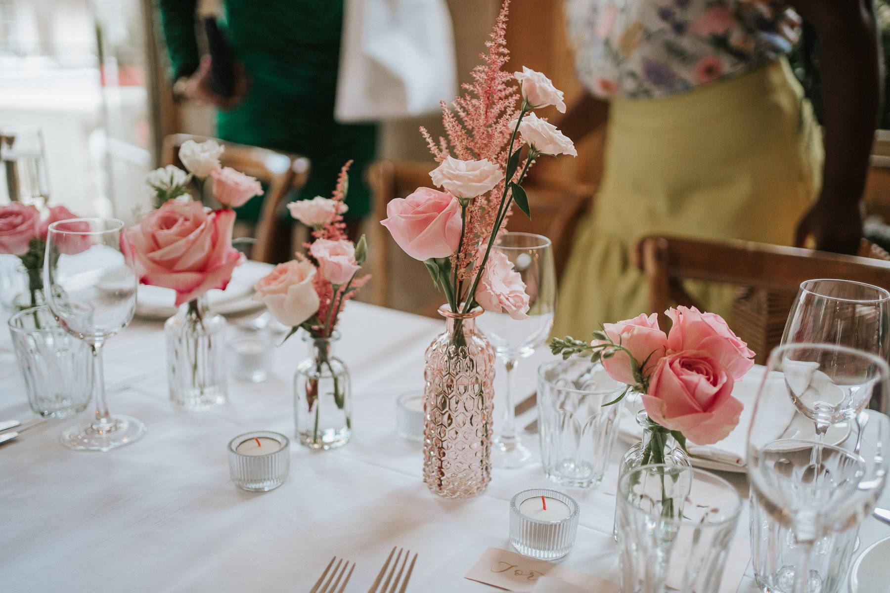  Small pink roses and other flowers in vases on table in the Main Dining Room of  The Orange  in Belgravia. 