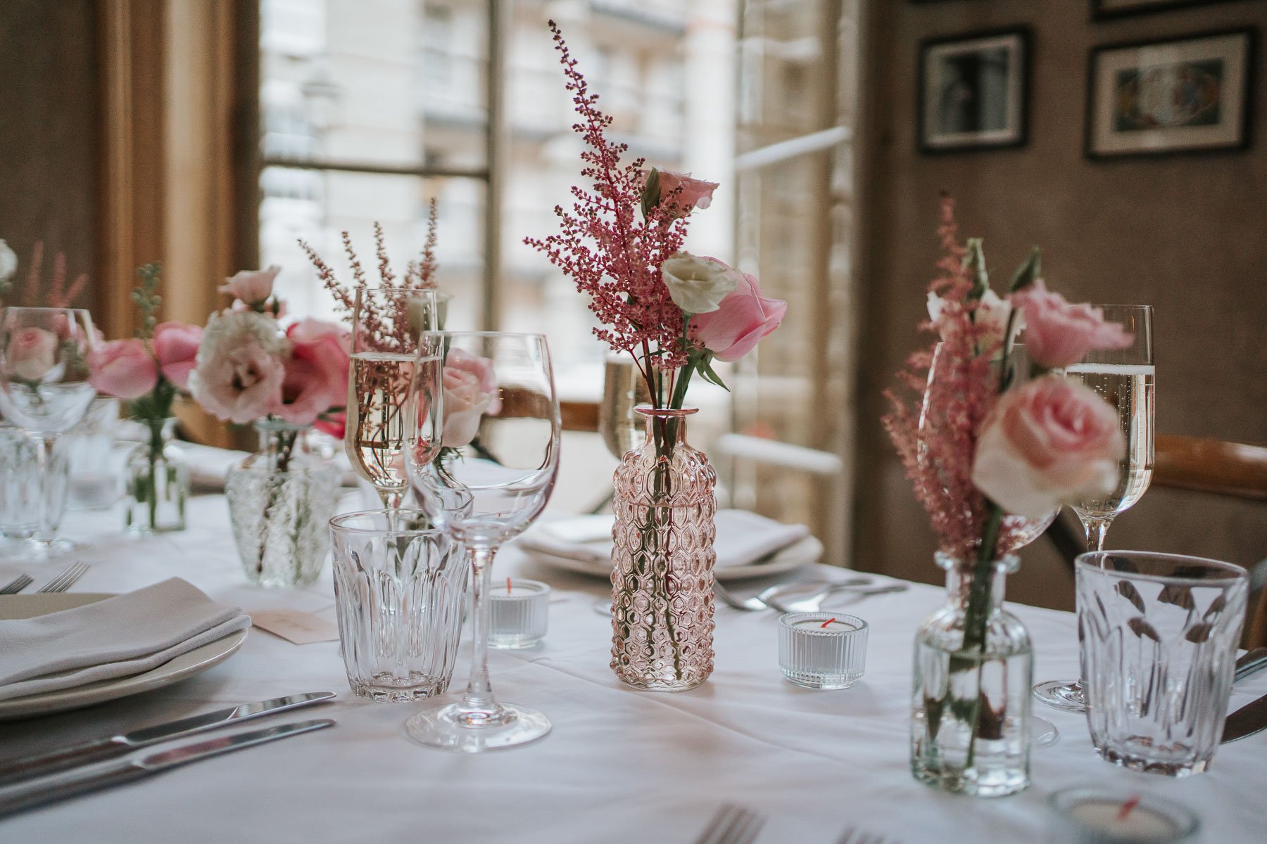  Small pink roses and other flowers in vases on table in the Main Dining Room of  The Orange  in Belgravia. 