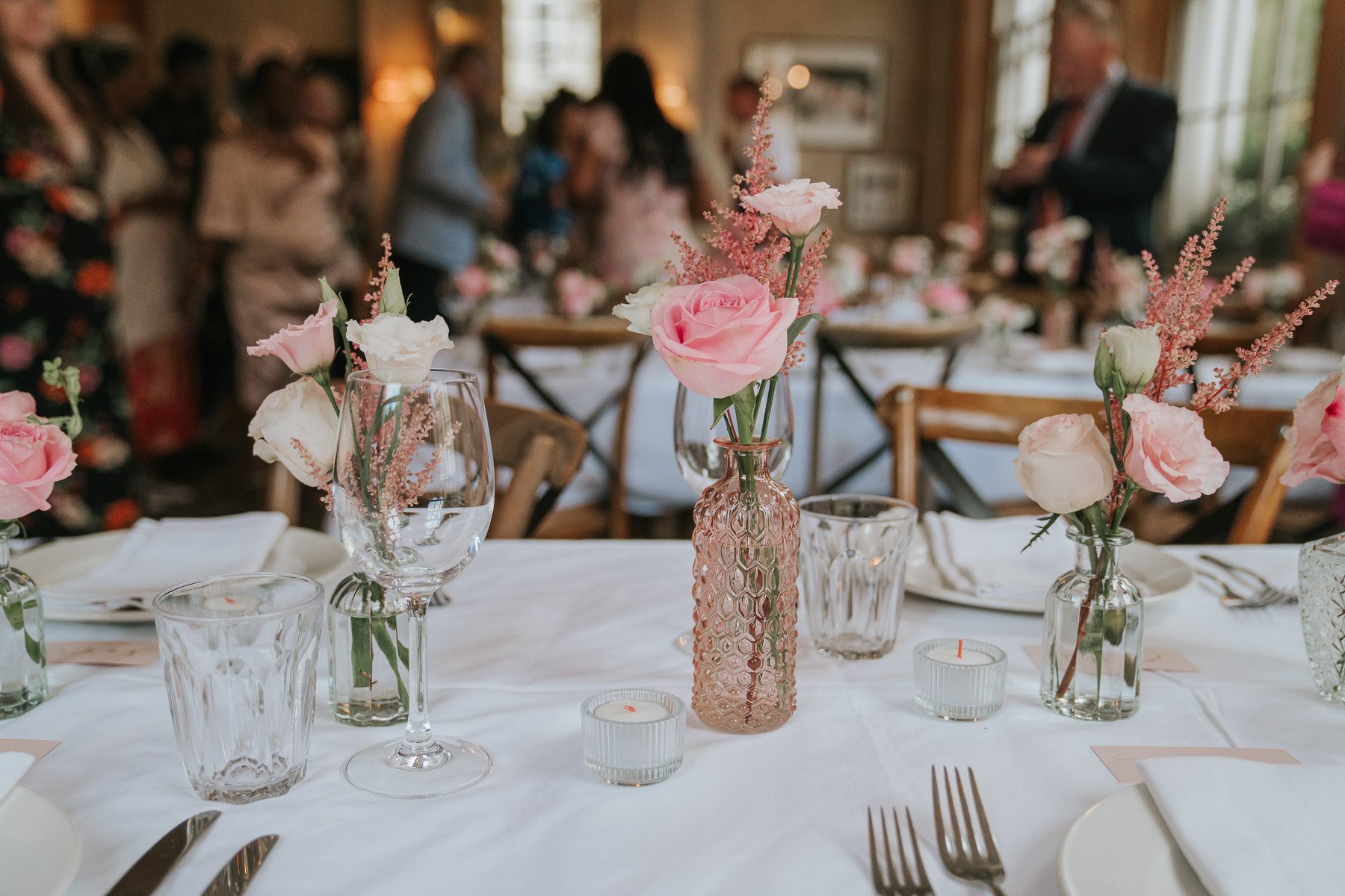  Small pink roses and other flowers in vases on table in the Main Dining Room of  The Orange  in Belgravia. 