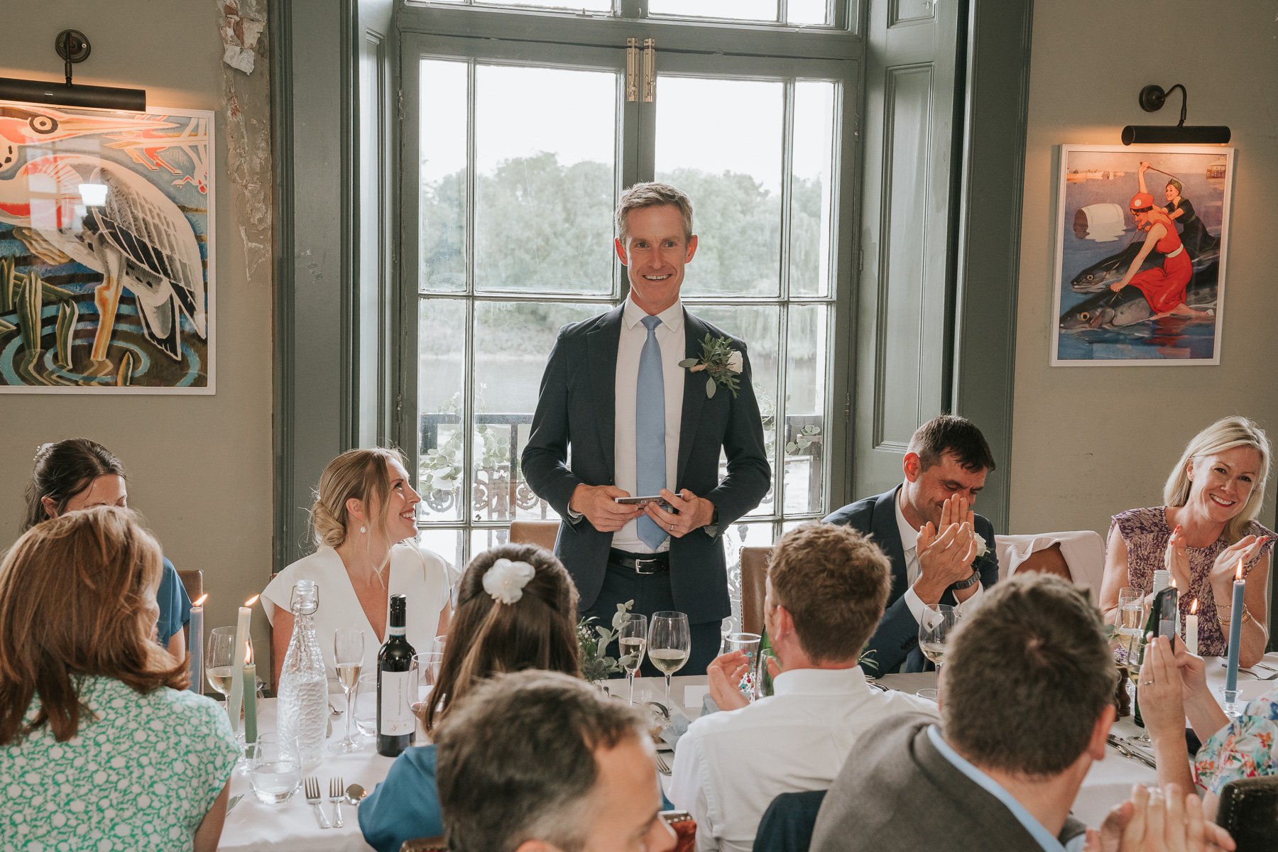  Groom stands at the dining table in The Melrose Room at The Bulls Head and gives speech. 