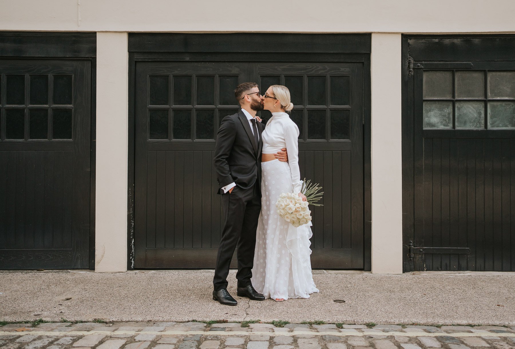  Bride and groom kiss in street near Marylebone Town Hall. 