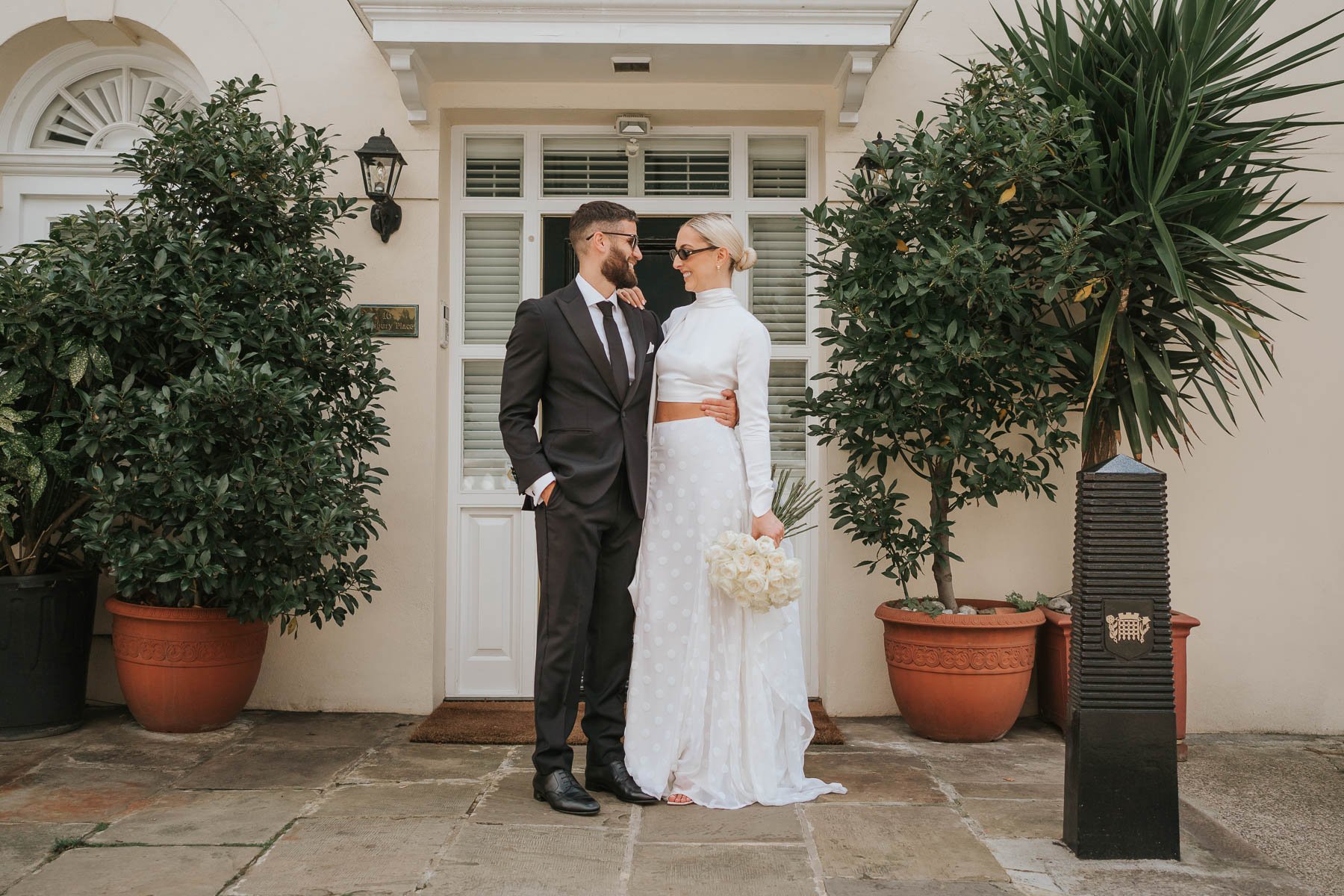  Bride and groom pose in front of pretty house behind Marylebone Town Hall. 