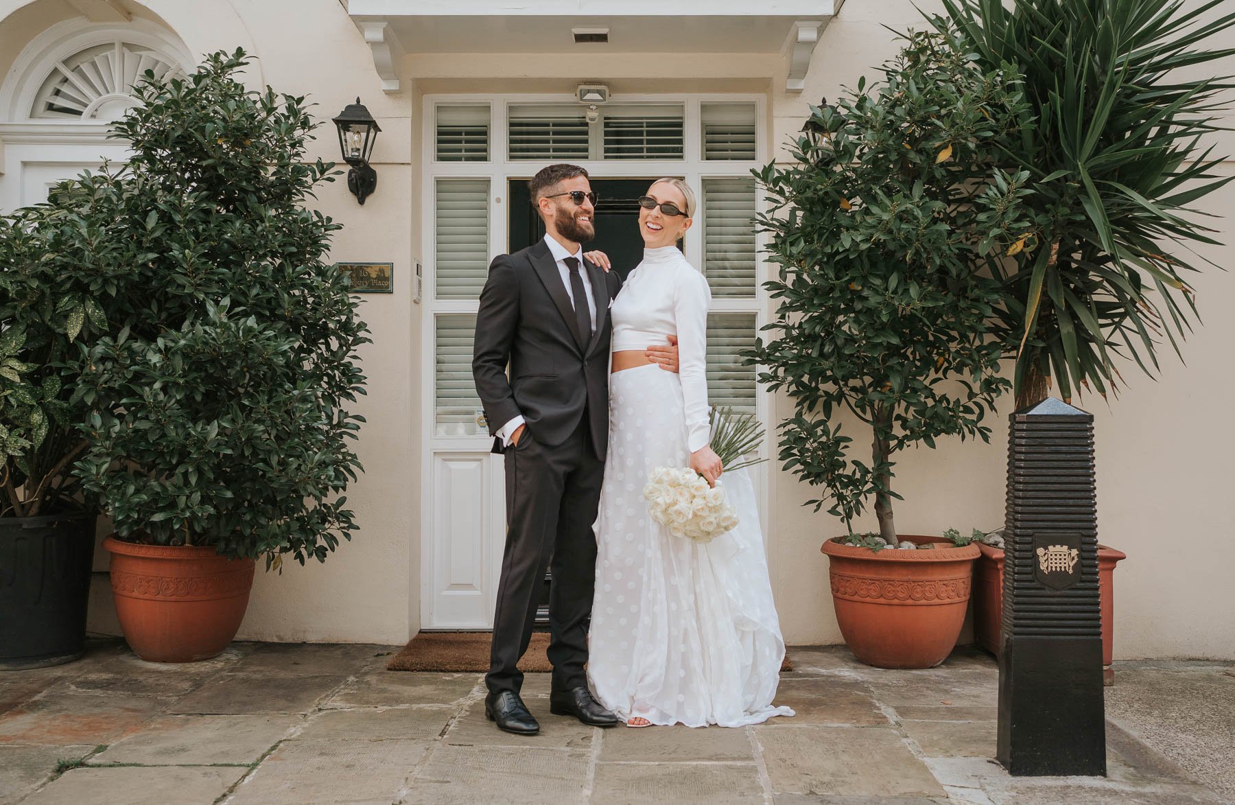  Bride and groom pose in front of pretty house behind Marylebone Town Hall. 