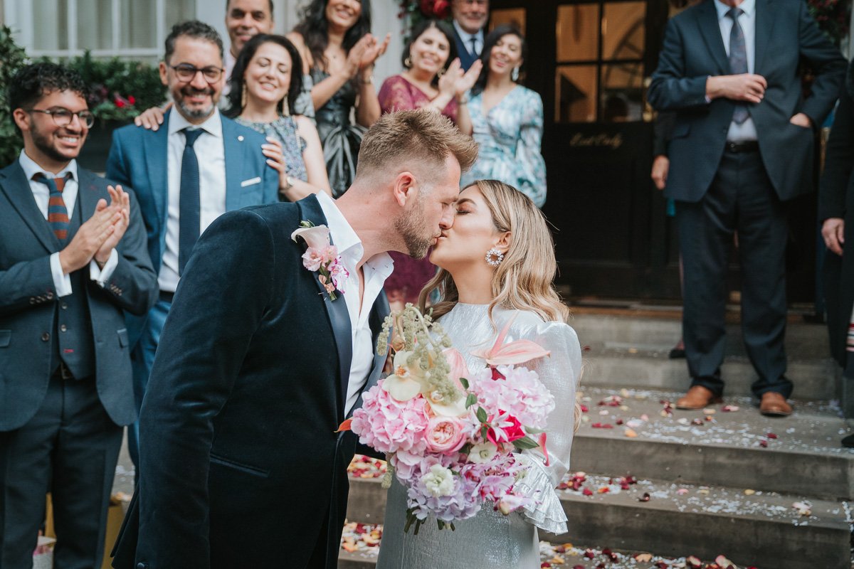  Bride and groom kiss on the steps of Chelsea Old Town Hall. 