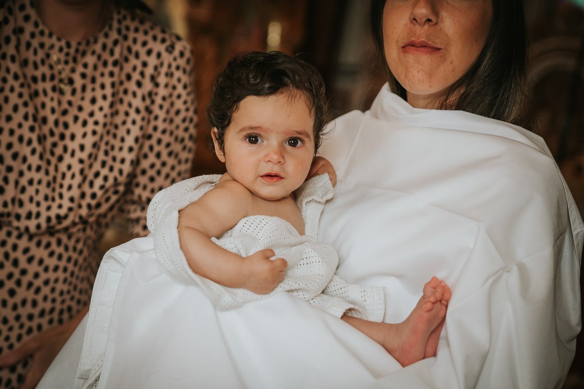  Godmother holds the baby girl after her christening. 