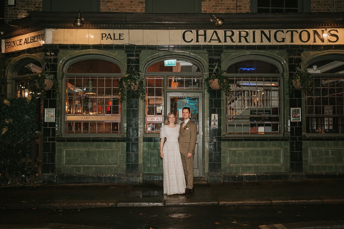  The just-married couple posing outside the Prince Albert Pub in Camden at night. 