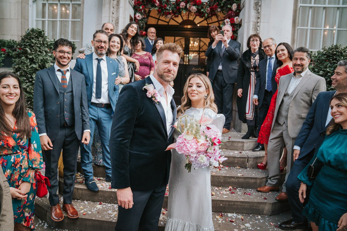  A newly-married couple pose for a photograph on the steps of Chelsea Old Town with their friends and family. 