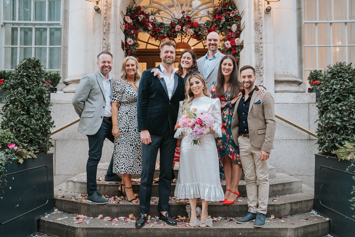  A newly-married couple stand on the steps of Chelsea Old Town with their friends and family and pose for a photograph. 