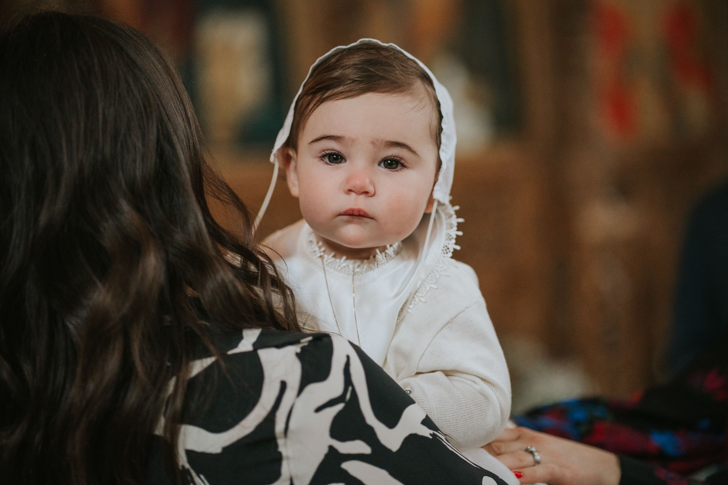  A baby boy in his Christening outfit after being baptised in the Greek Orthodox Church. 
