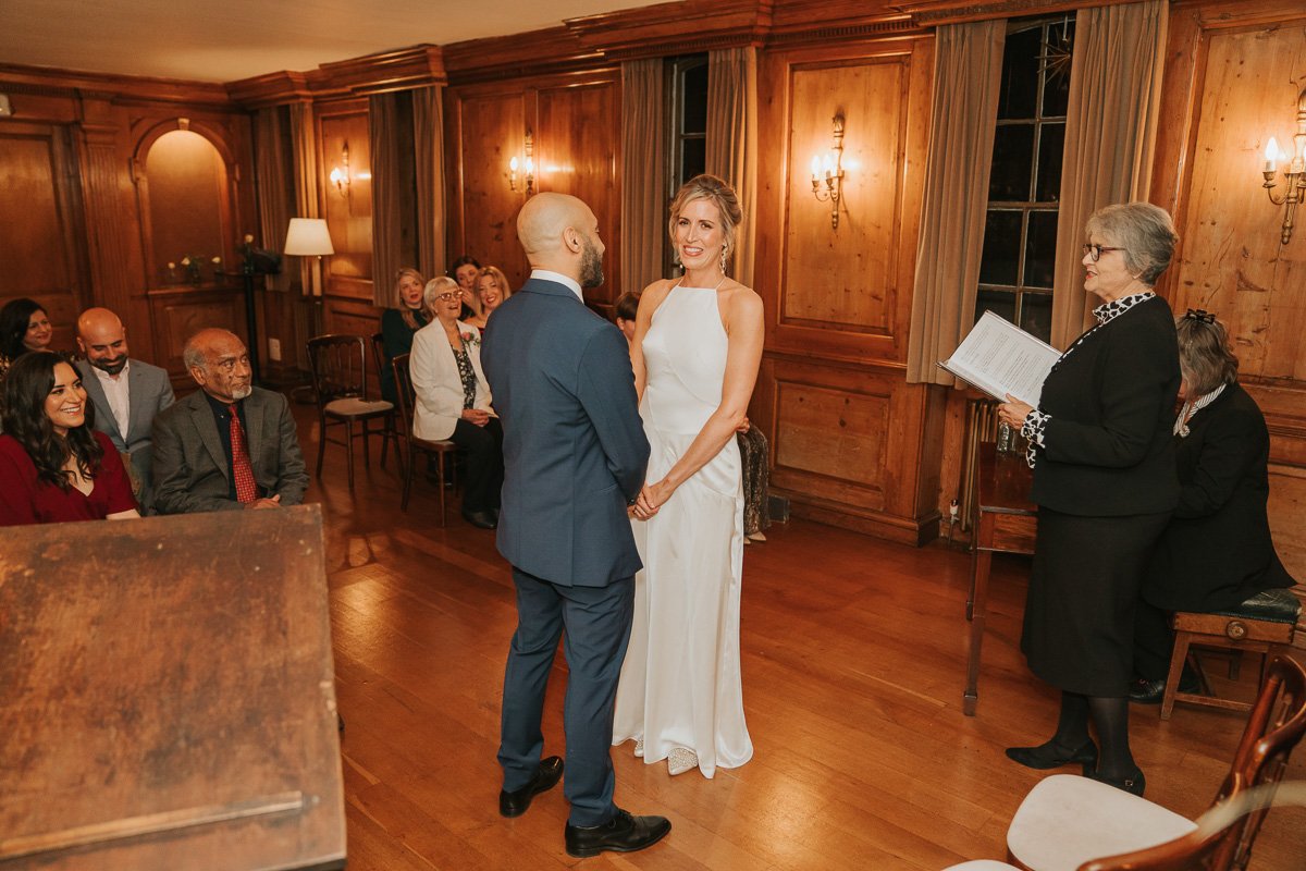  Man and woman exchange wedding vows in the wedding room of Burgh House. 