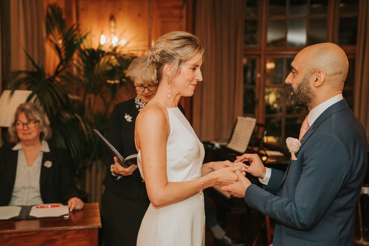 Groom places ring on Brides finger at Burgh House. 