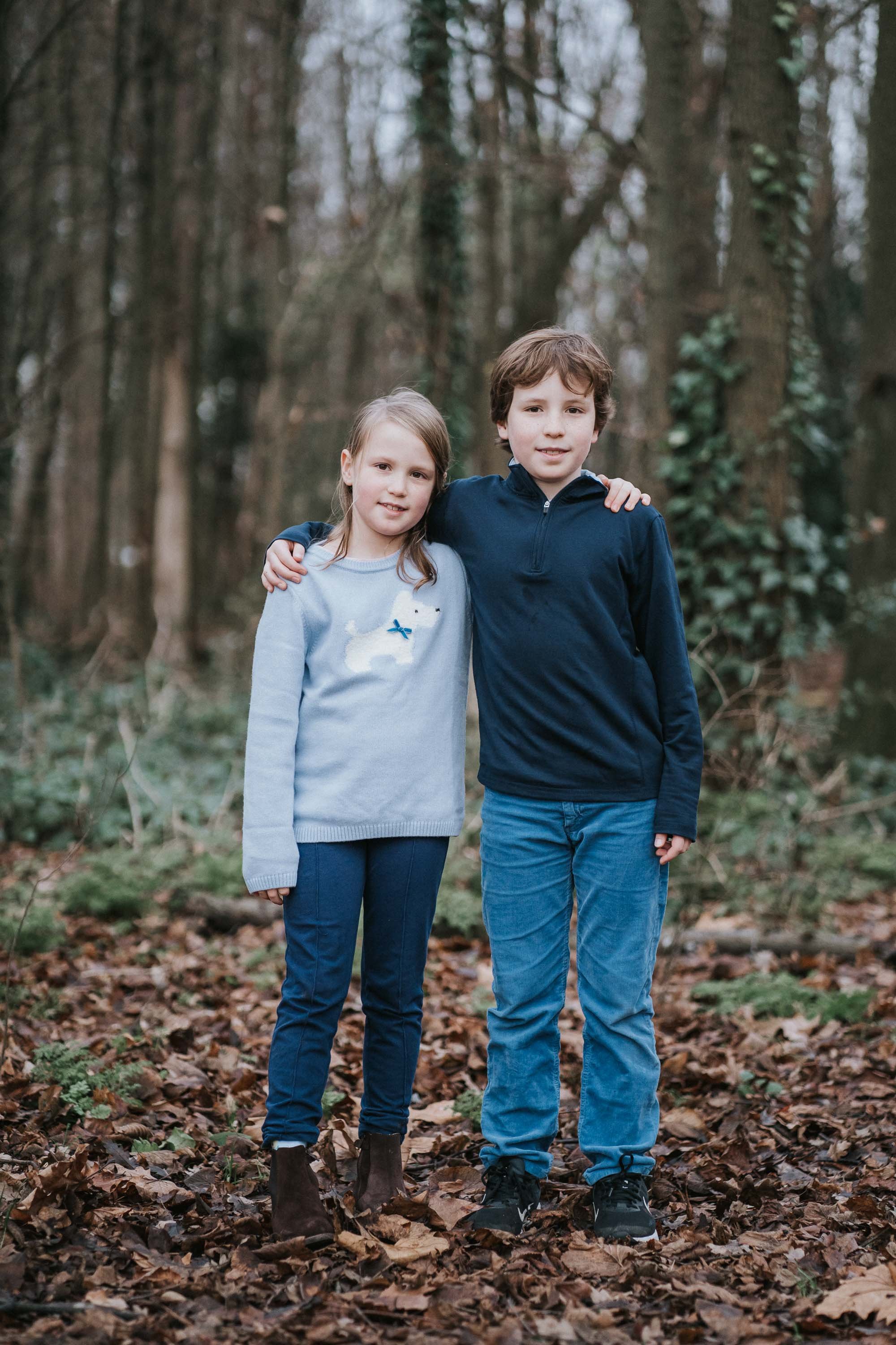  A girl and her brother pose for a photograph in the small woods on clapham common. 