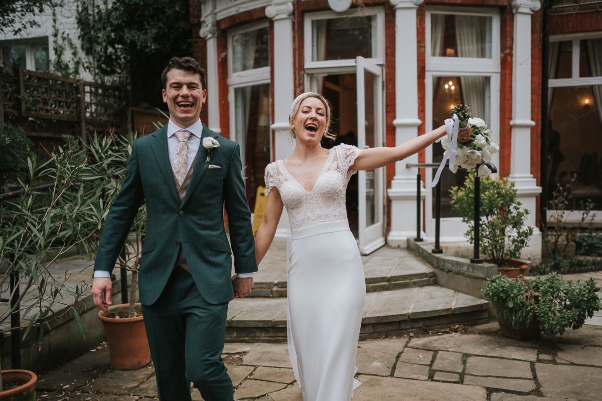  A jubilant and just-married Tanya and Chris step out into the garden after their civil ceremony at Southwark Register Office. 