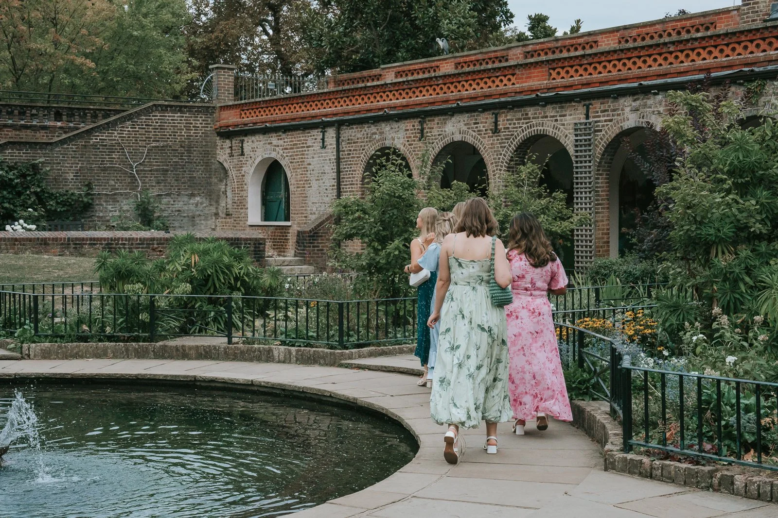 Wedding guests walking through Holland Park gardens