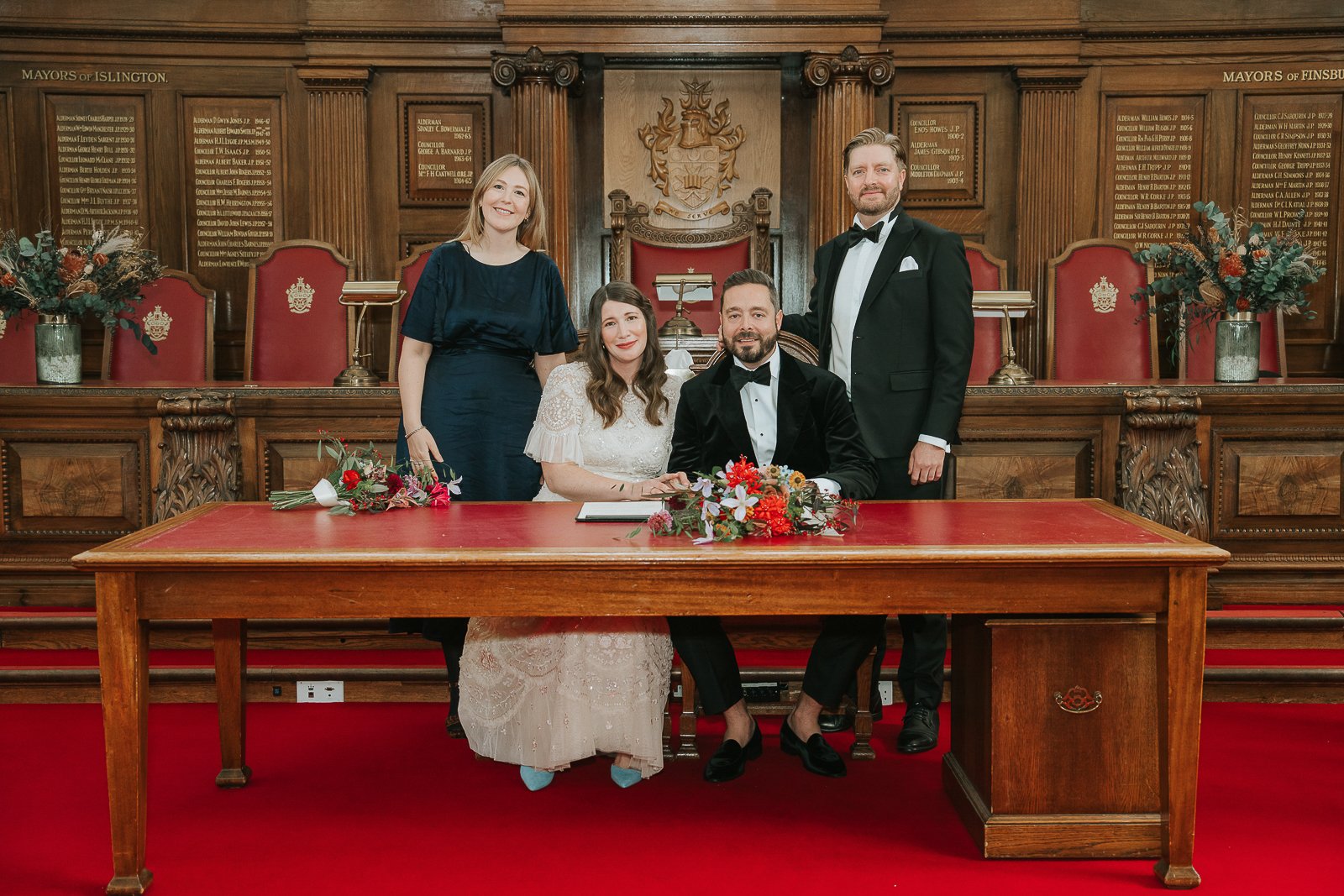  Newlyweds signing the register with their witnesses during their Islington Town Hall wedding ceremony, captured in the elegant Council Chamber. 