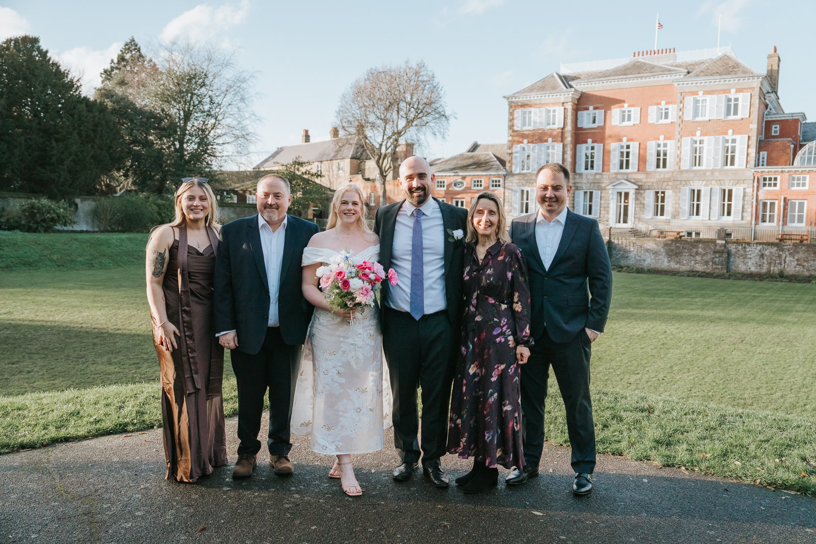  Group family portrait in front of York House, Twickenham, taken after the wedding ceremony with the historic building visible in the background. 